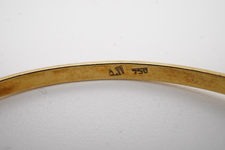 A modern continental 18k and single stone tiger's eye quartz set bangle, gross weight 7 grams.